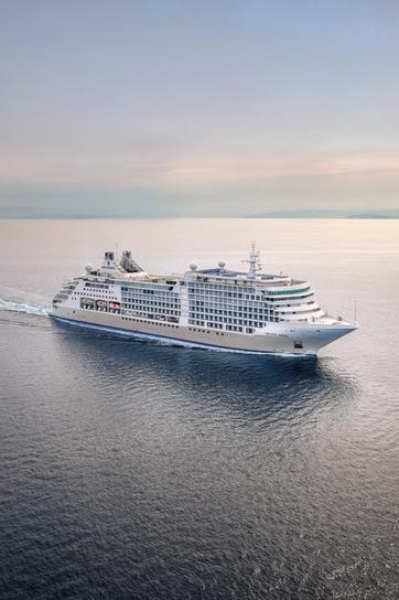 Passenger looking out over the ocean from a luxury cruise balcony