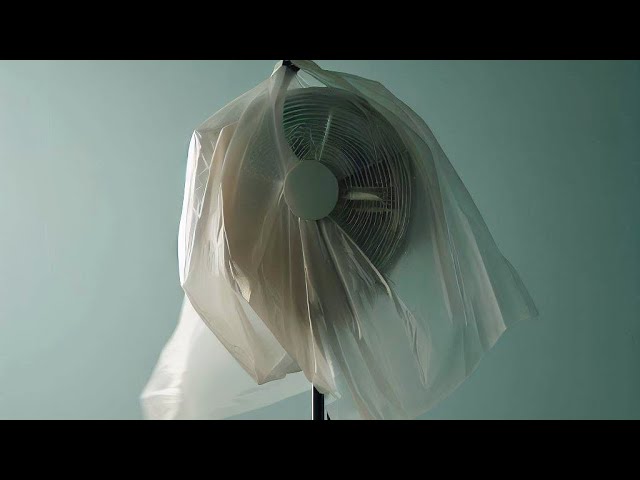 Demonstration of cleaning a fan grill using a vacuum cleaner brush attachment without removing the cover