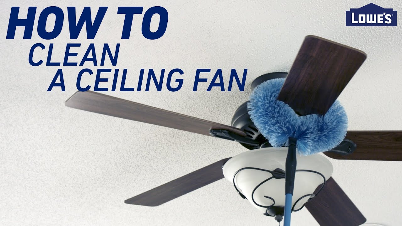A person using a step ladder to reach a ceiling fan, preparing to clean the blades