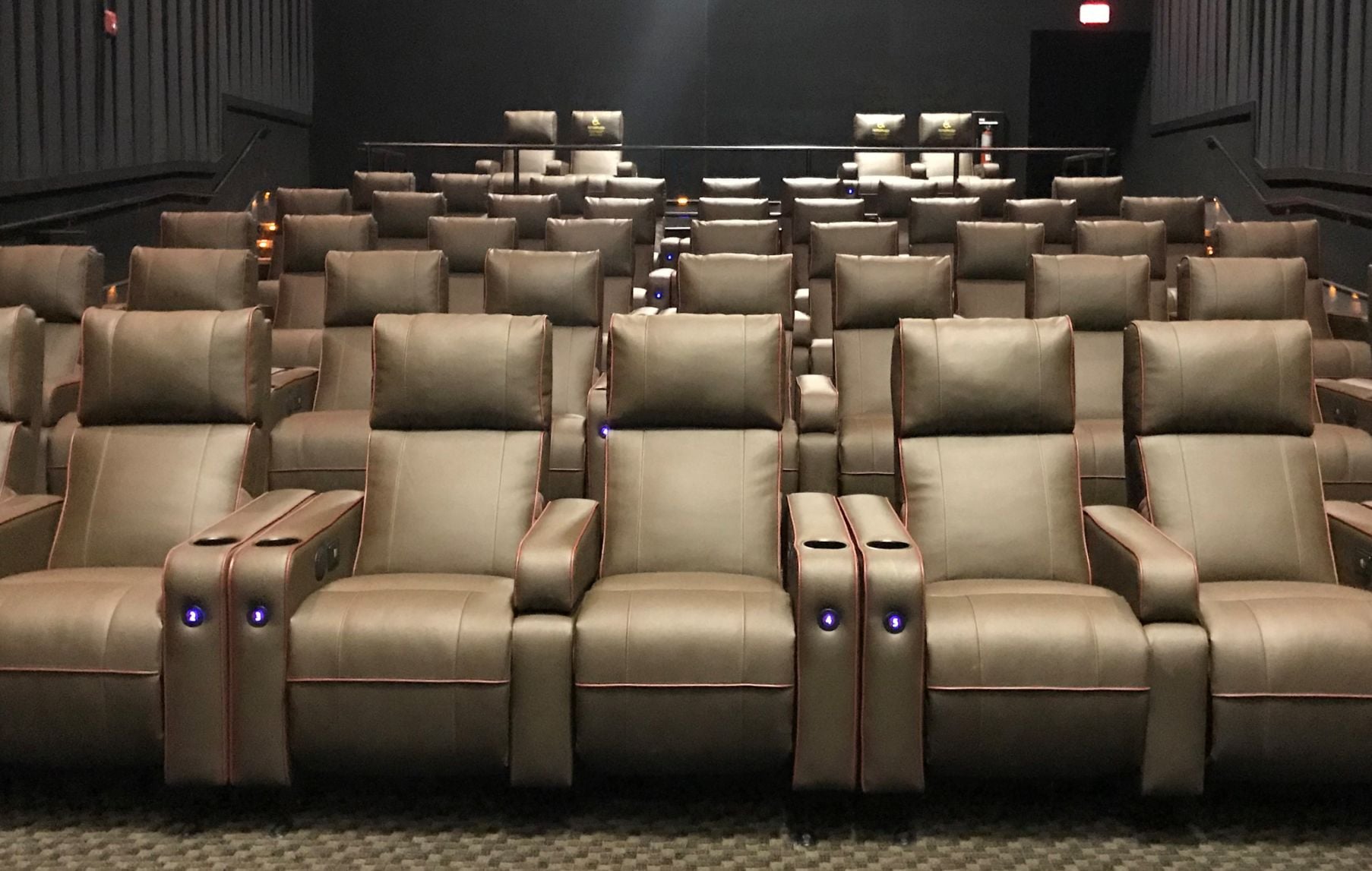 Interior view of an AMC auditorium featuring plush red power reclining seats