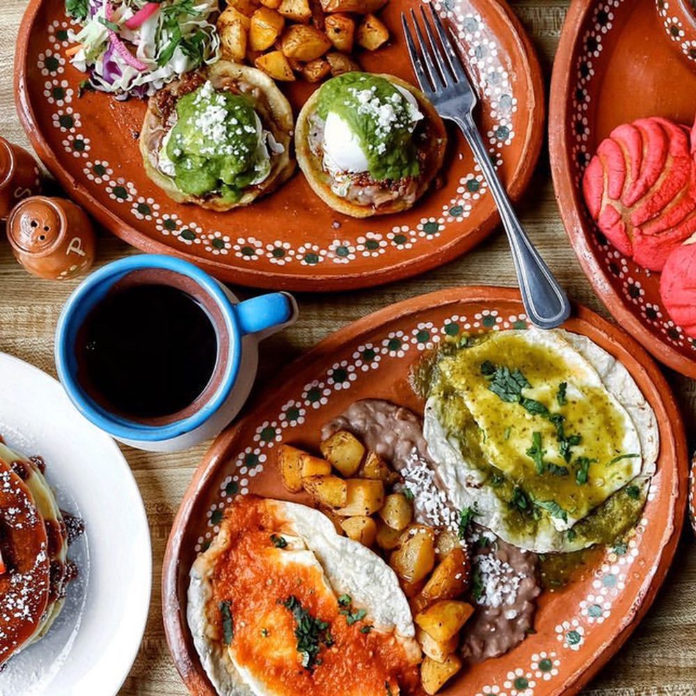 A close-up of authentic Birria tacos with a side of rich, red beef consommé for dipping