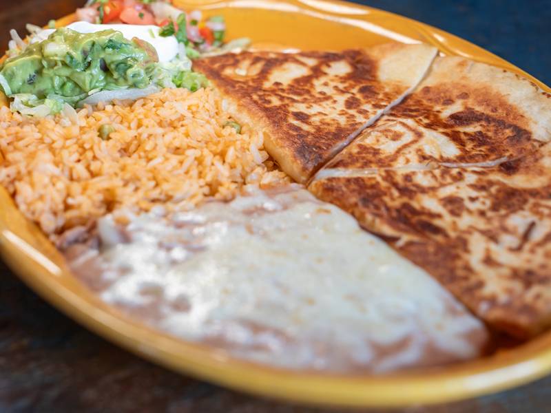 A large, hearty burrito cut in half, showcasing layers of rice, beans, and savory fillings
