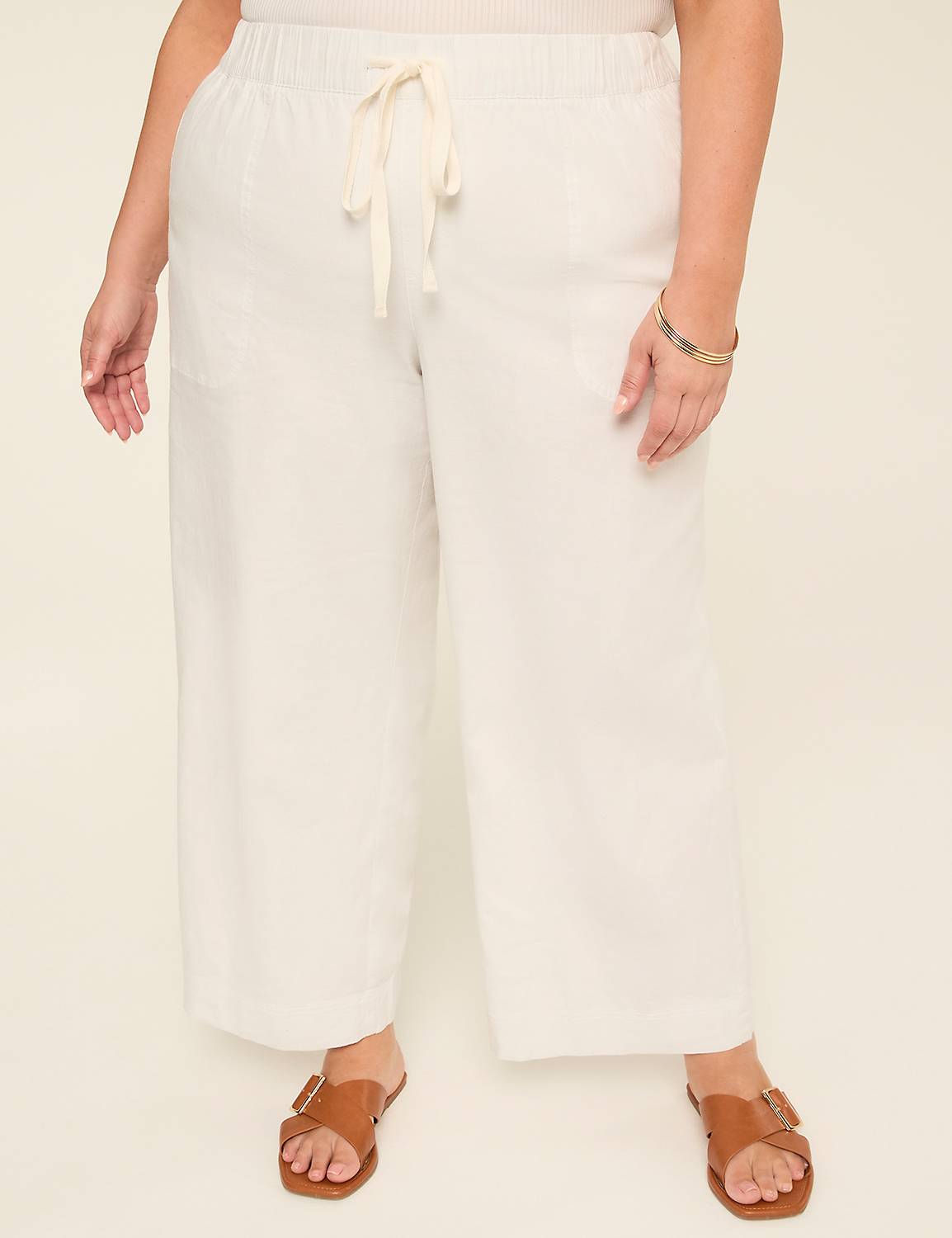 A model wearing soft white linen wide leg pants with a relaxed fit
